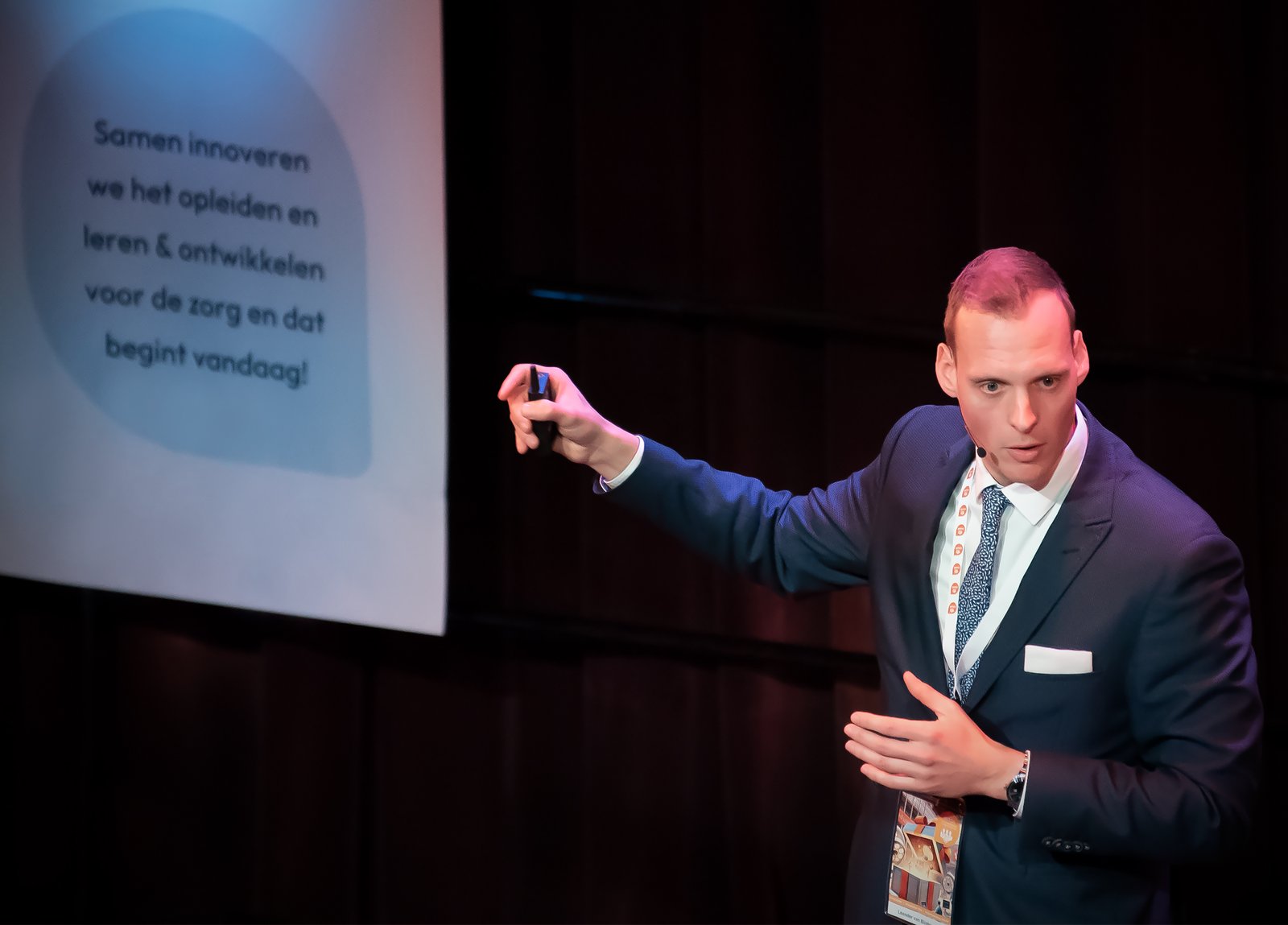 Leander wijst naar een slide tijdens zijn presentatie